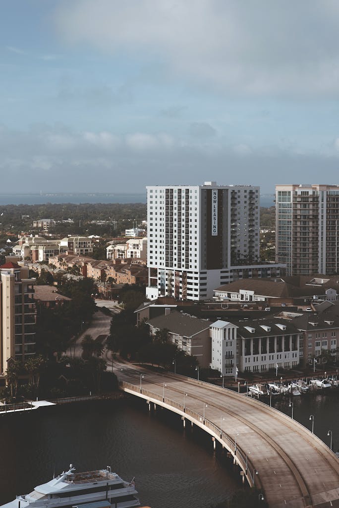 A high-angle view of a modern city skyline with a bridge over the waterfront.